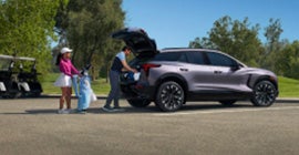 A family packing up their golf clubs in the back of the Blazer EV