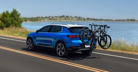 A blue Equinox EV with a bike rack
