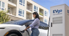 A woman charging her white Equinox EV