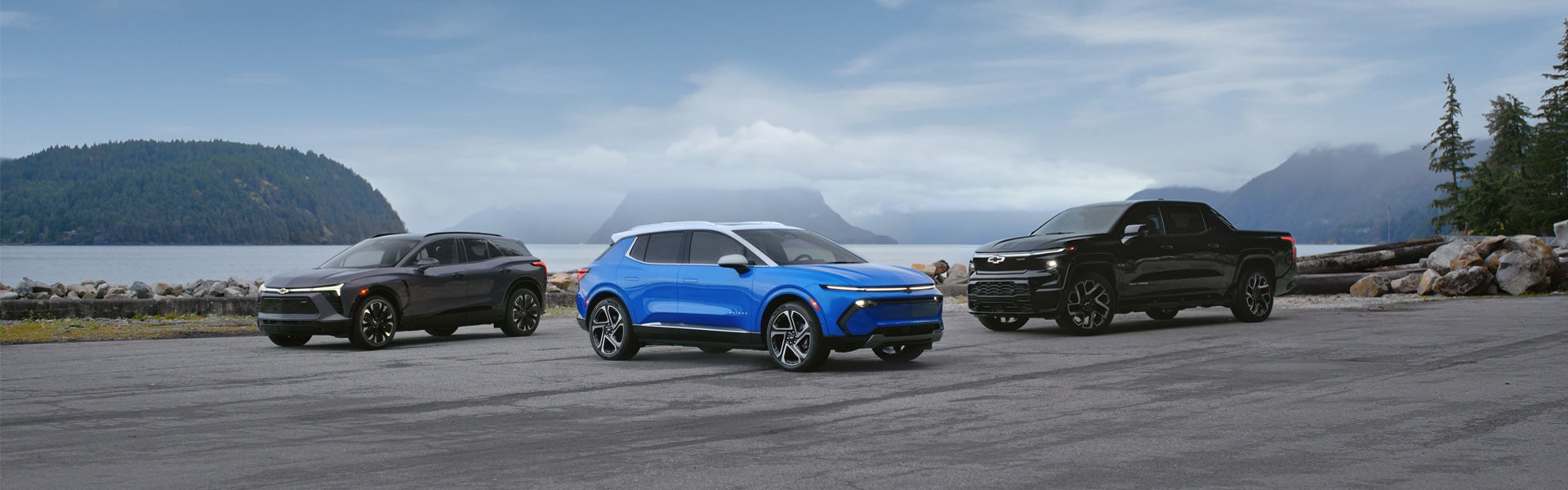 Three Chevy EV's parked in a lot by the ocean
