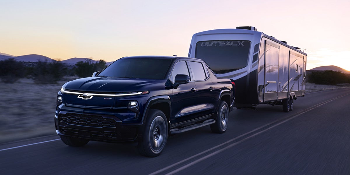 A black Silverado EV towing a RV trailer